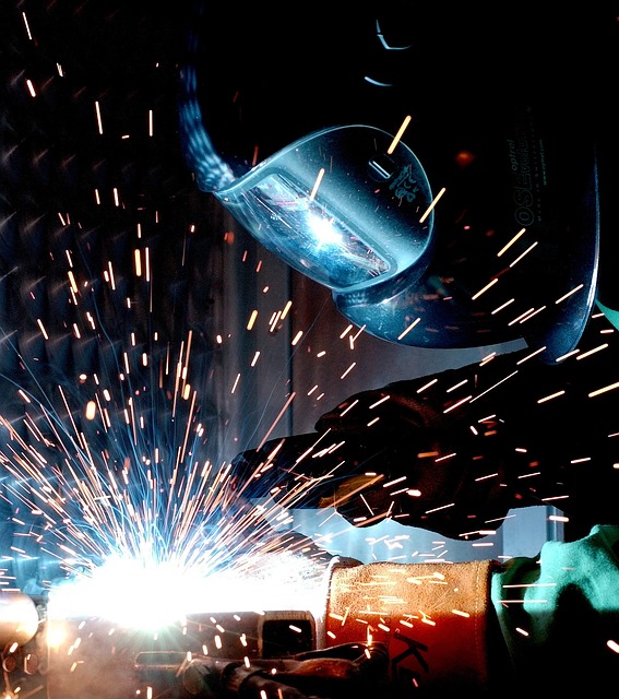masked welder welding steel